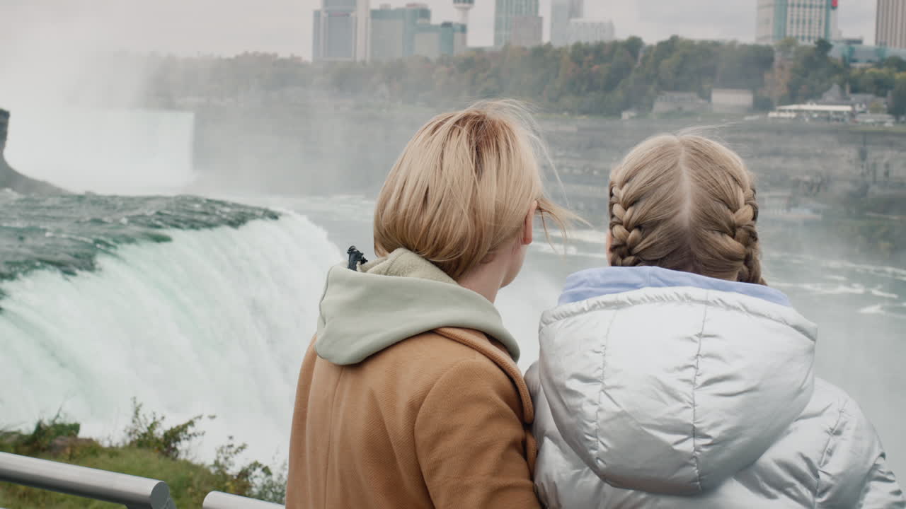 Madre e figlia ammirano le Cascate del Niagara. Sono in piedi sul lato americano della cascata.