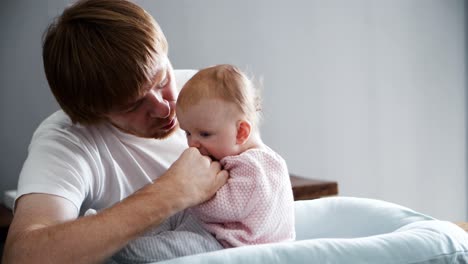 padre emocionado entrenando a la hija bebé para sentarse