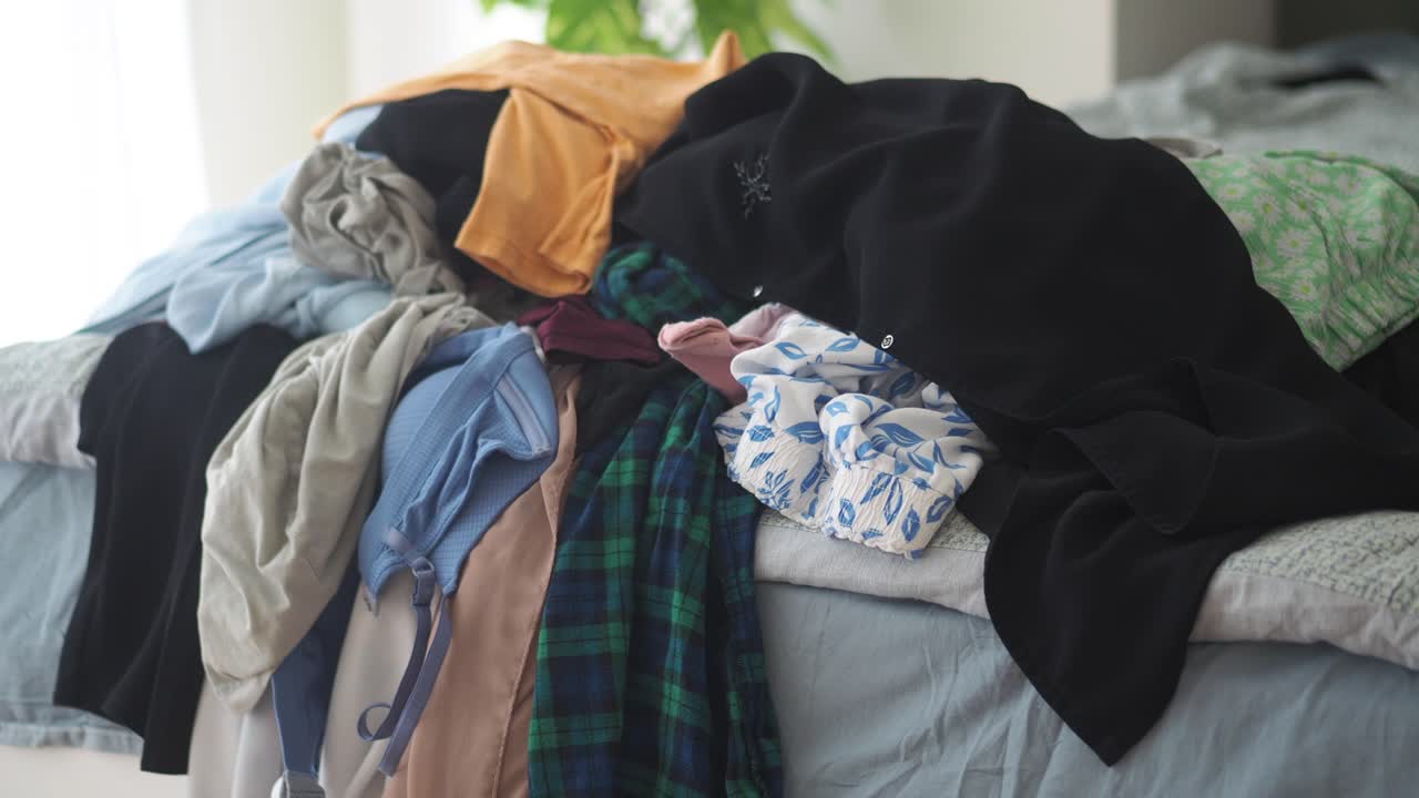 침대 위 에 있는 옷 어리