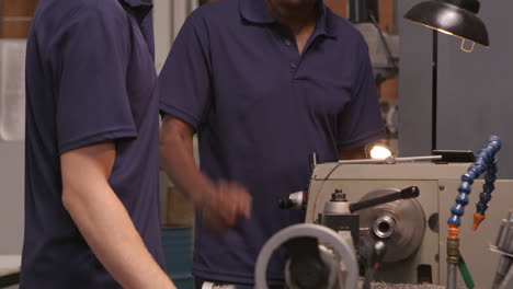 engineer training male apprentice on lathe shot on r3d