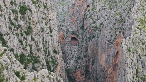 aerial drone in majorca, a cave located high in the mountains, on the side of a cliff