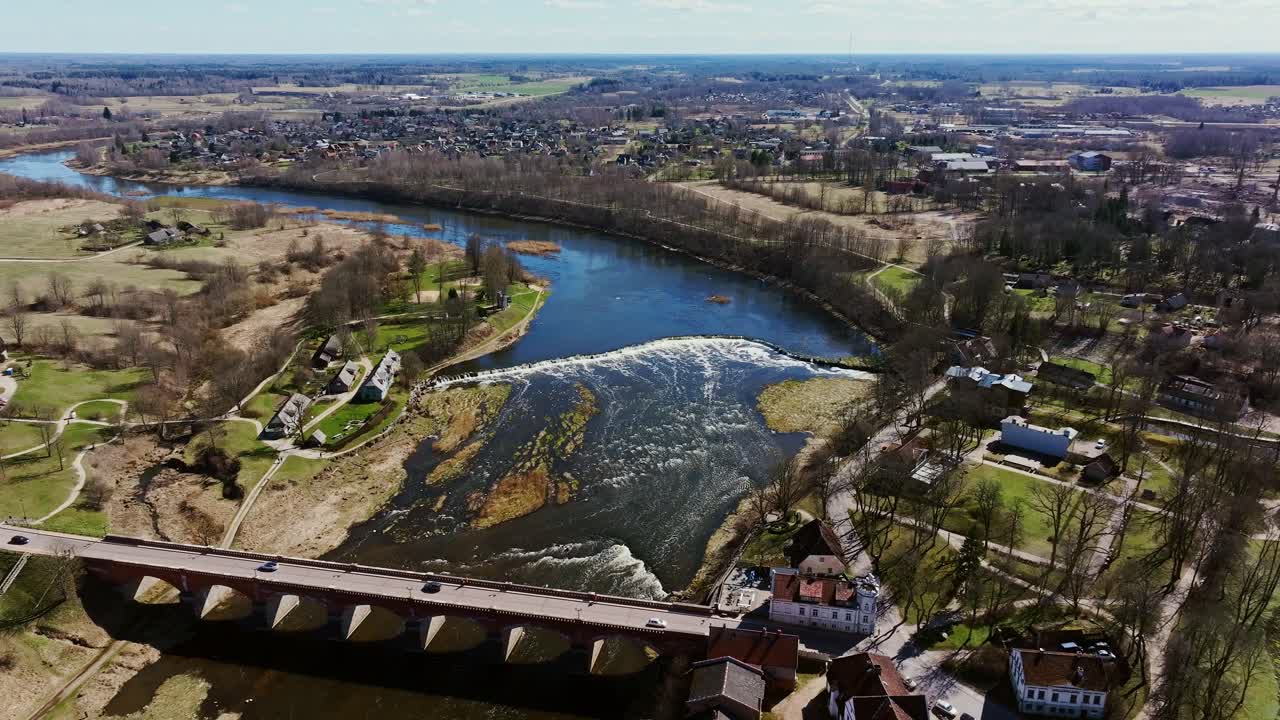 Aerial view of Ventas Rumba, widest waterfall in Europe, Kuldīga’s red bridge