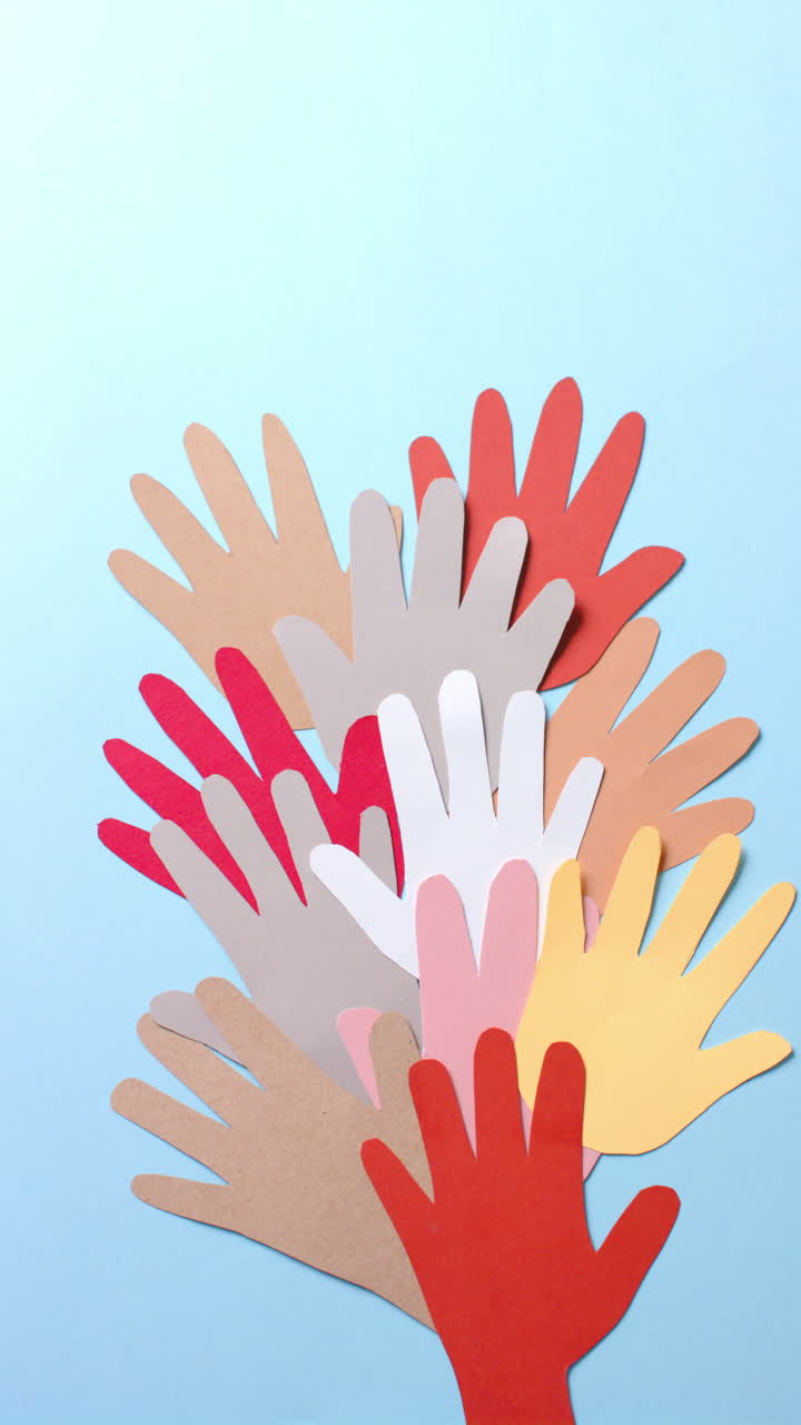 Vertical video of hands made of colourful paper on white background with copy space