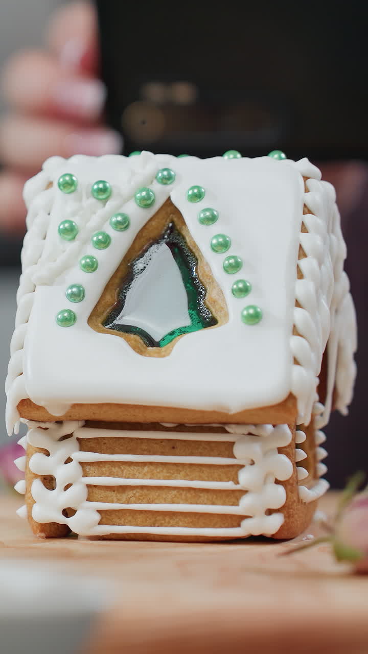 primer plano de un cuenco de galletas con pan de jengibre casa en una bandeja de madera, decorada con hielo y cuentas, flores secas añaden encanto mientras la persona borrosa