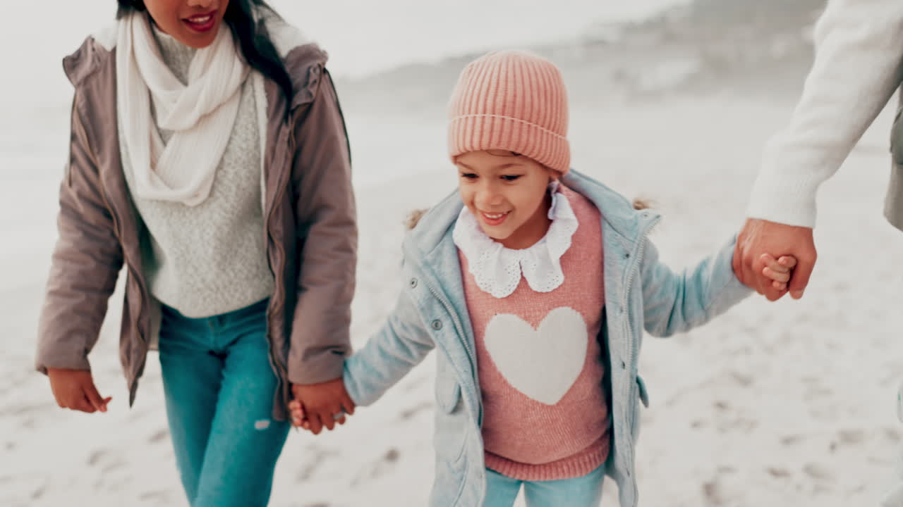 겨울에 해변을 산책하는 가족
