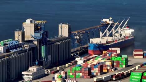 buque de carga atracado en el puerto logístico con pilas de contenedores intermodales almacenados en vancouver, canadá