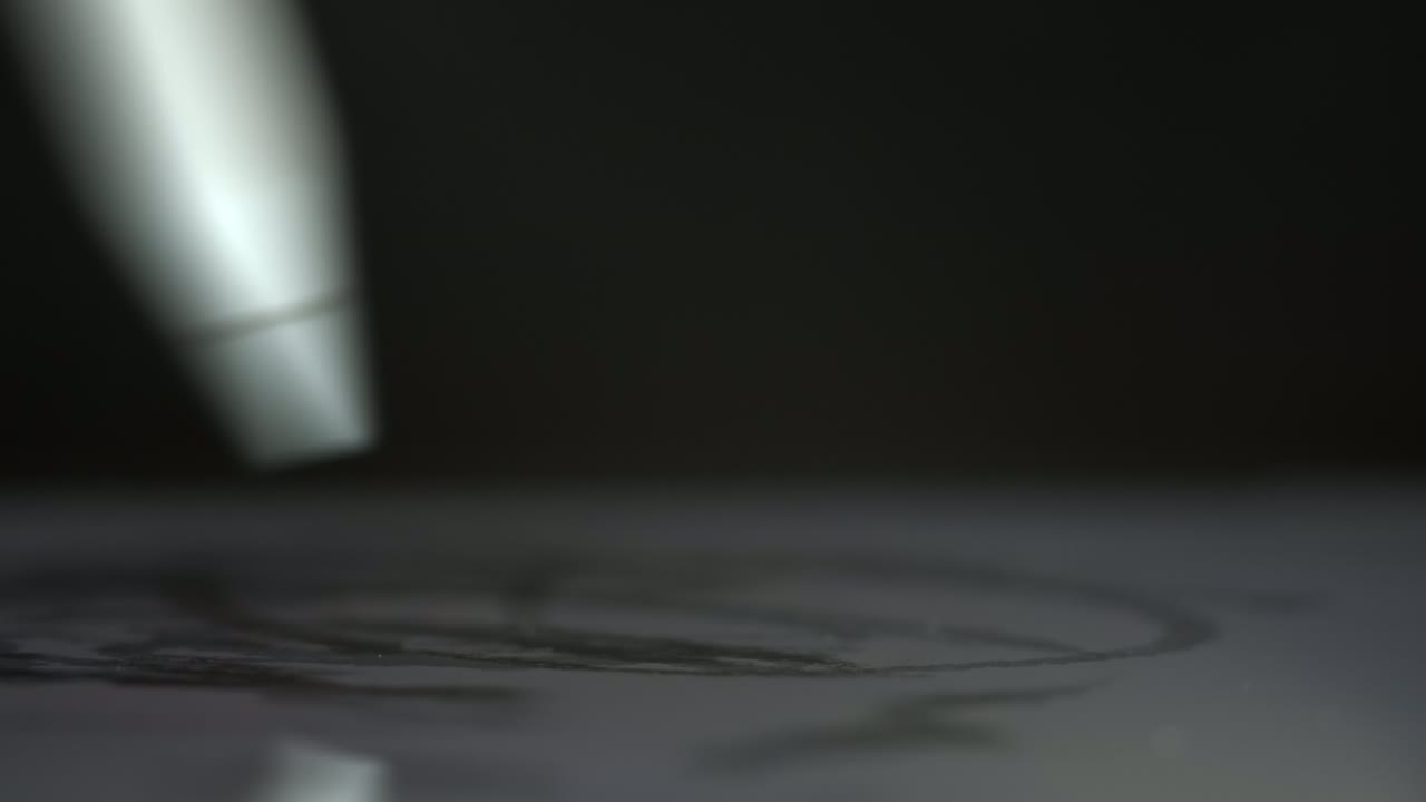 Person draws with white digital pen on screen of tablet