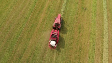 aerial view of a modern tractor with a roll wrapper that packs hay with plastic wrap