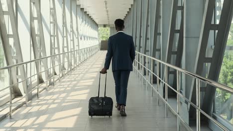 businessman pulling luggage at airport