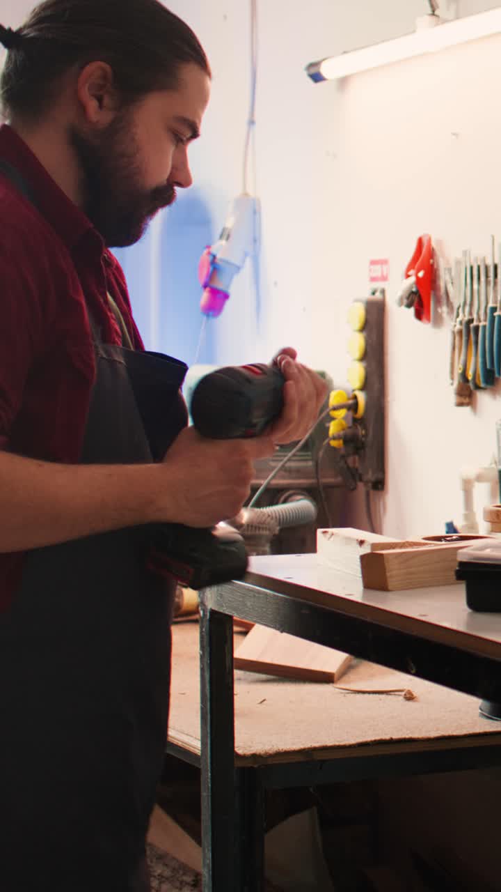 Artesano taladrando agujeros en madera en un taller