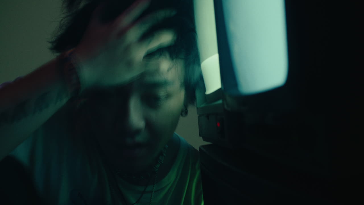 young male sleeping tired in front of the old crt vintage monitor television