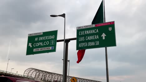 mexican flag and highway signs in mexico city