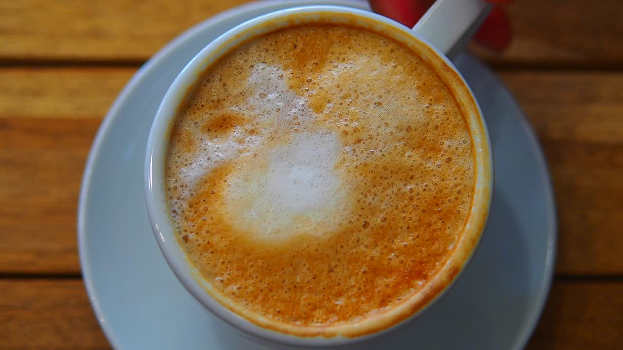 A close-up overhead shot of a cup of frothy coffee
