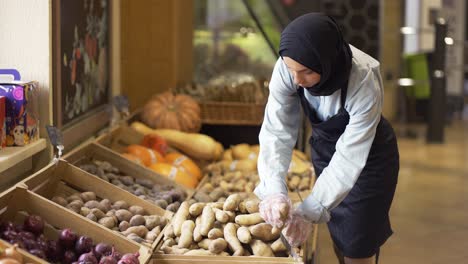 Frau-Im-Hijab-Füllt-Die-Kartoffeln-Auf-Dem-Vorrat-Im-Supermarkt-Auf