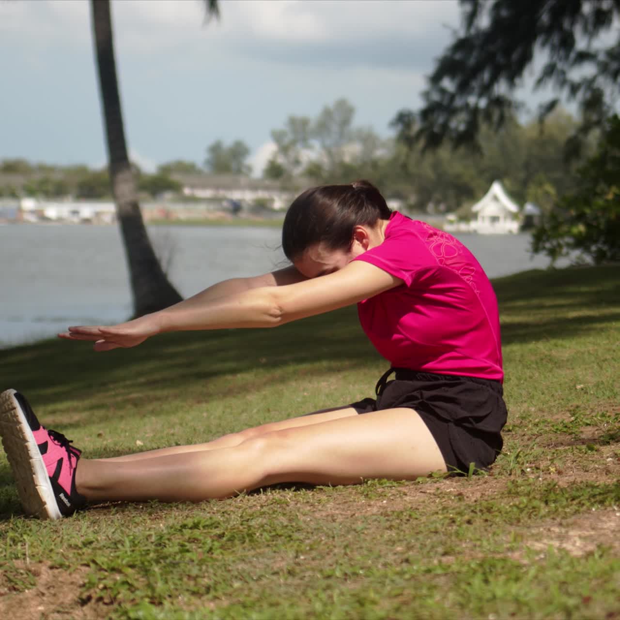 mujer deportiva haciendo ejercicio de estiramiento en la orilla del lago