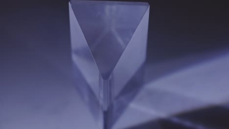 luz que se refracta a través de un prisma transparente triangular con sombra