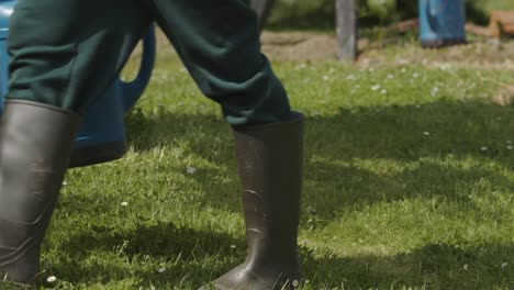 person takes watering can to start the gardening work