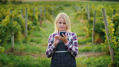 A-Satisfied-Female-Farmer-Uses-A-Tablet-Near-His-Garden-Evening-Before-Sunset