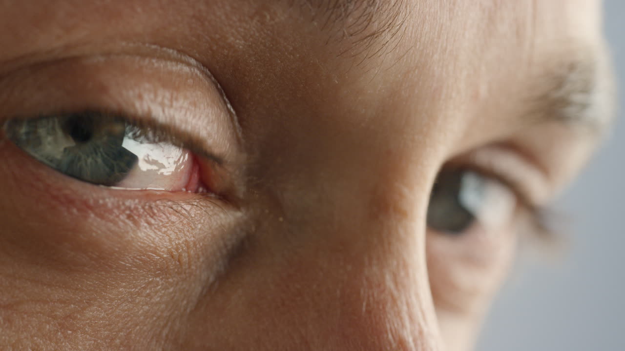 눈을 감고 생각나는 젊은 남자가 아름다운 파란 아이리스의 매크로  ⁇ 을보고 있습니다.