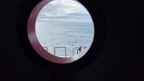 view of the ocean through a porthole from the inside of a ship
