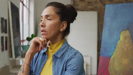 Video-of-thoughtful-biracial-female-artist-in-studio