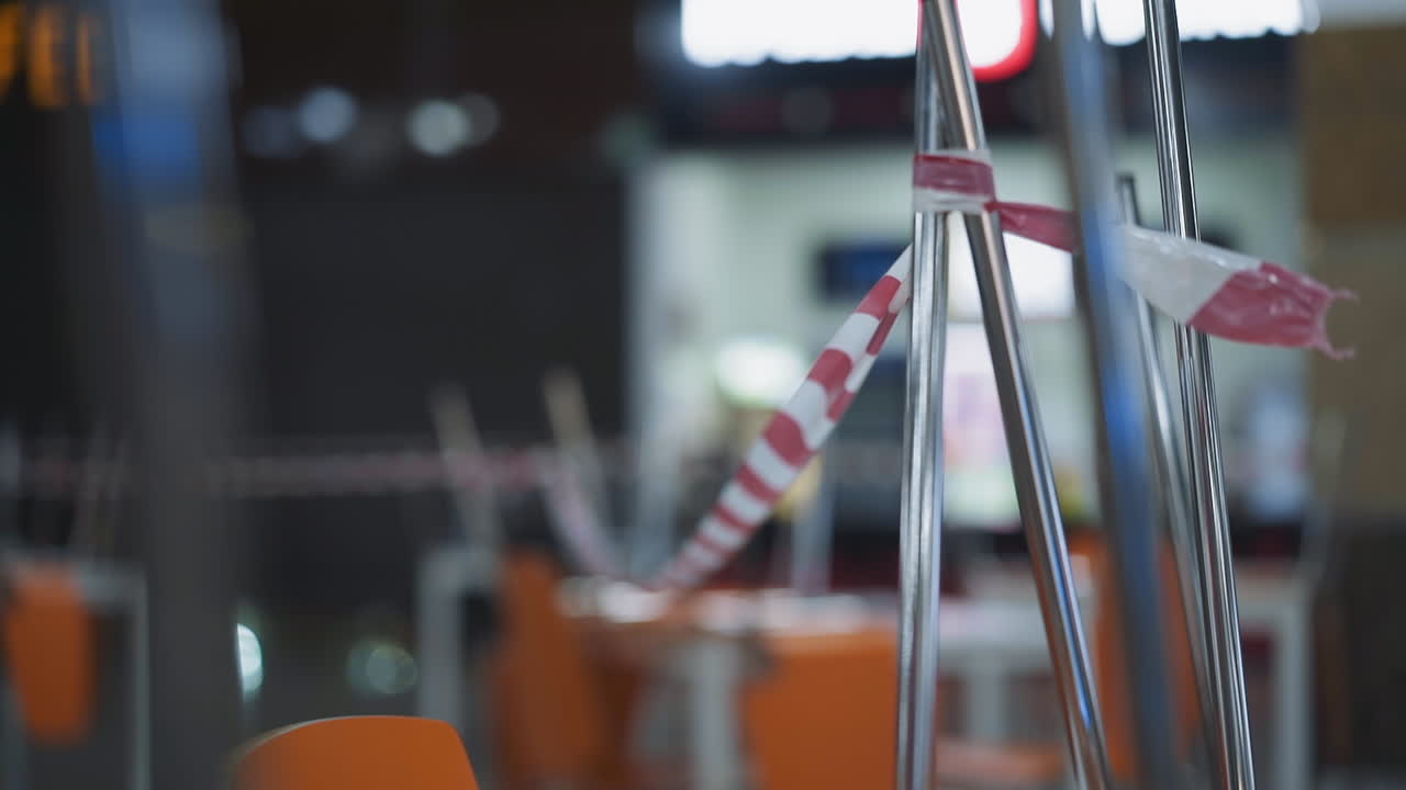 Striscia di avvertimento sulle sedie in un caffè chiuso per quarantena.