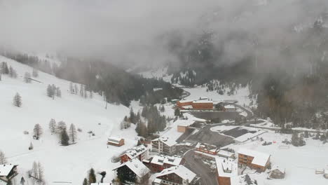 aerial view through clouds of accommodation buildings by the snowy mountain in uzbekistan in winter