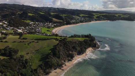 vista aérea de la tranquila playa de langs, una pequeña bahía con playa de arena en nueva zelanda
