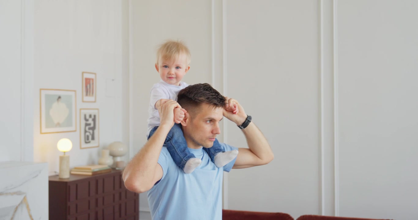 Happy Father Giving His Baby a Shoulder Ride at Home