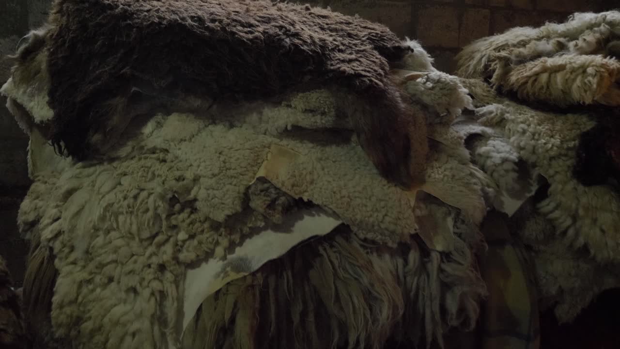 pieles curtidas de ovejas, llamas y llamingos amontonadas en las mesas