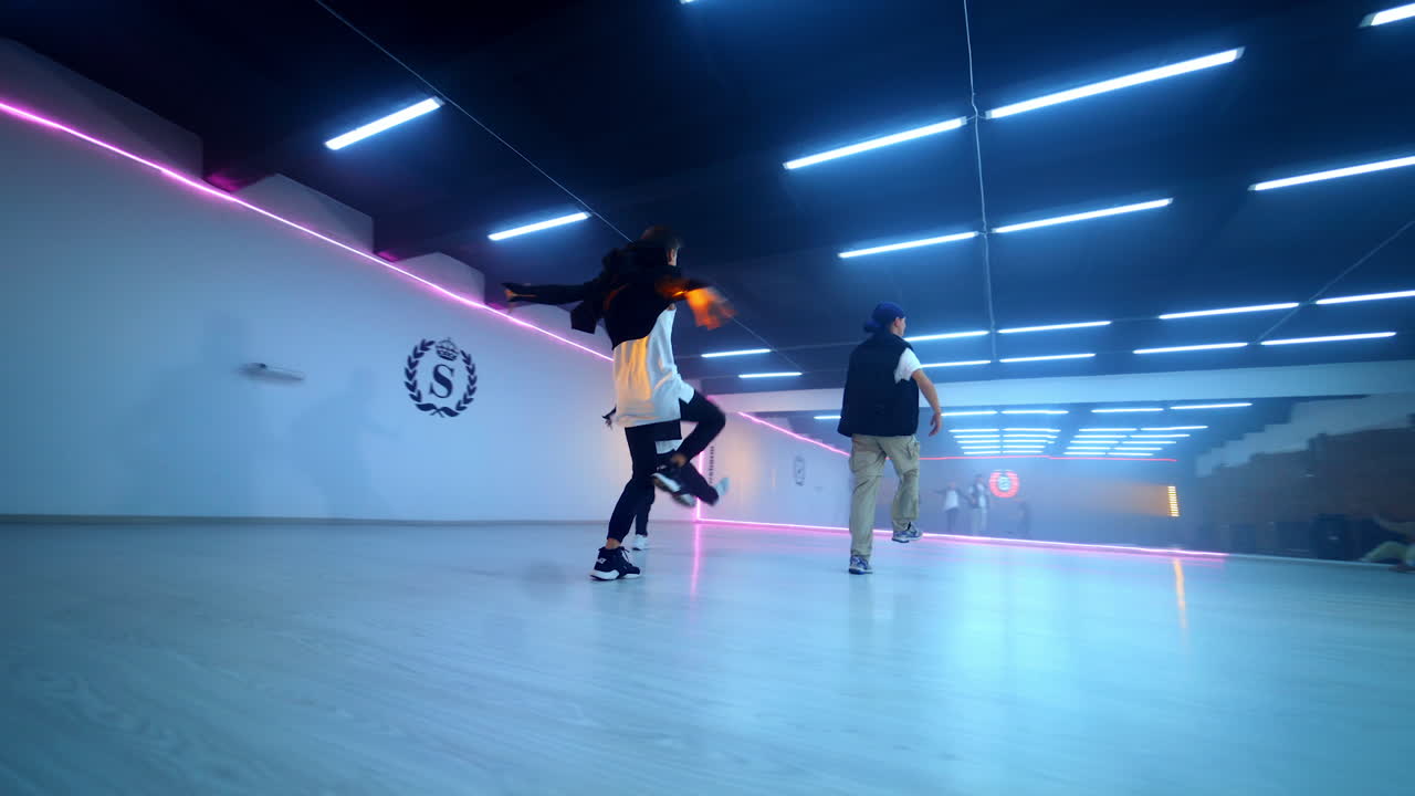 Boys band dancing in the spacious room. Hip hop dancers performing in the studio. Low angle view.