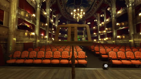 empty theater stage with music stand and audience seating during performance