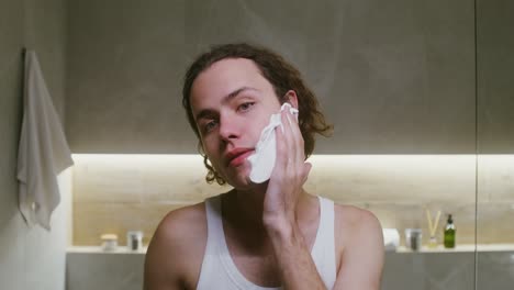 man shaving in bathroom