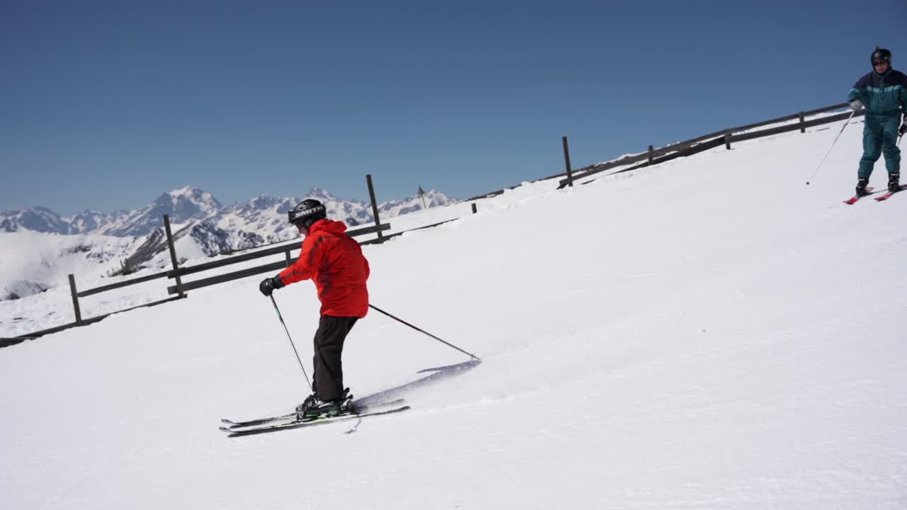 Sciatore con giacca rossa che scende la pista d'inverno.