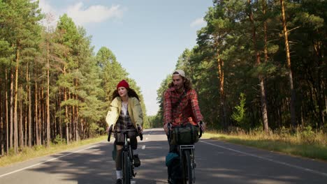 couple cycling through forest