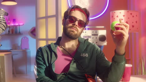 man holding tennis ball in a retro 80s style room