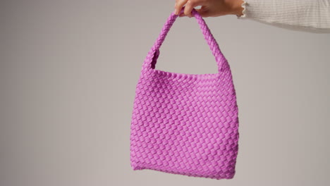 Close-Up-Of-Female-Social-Media-Influencer-Producing-User-Generated-Content-Holding-Out-Purple-Fashion-Bag-2