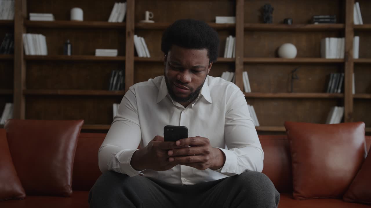 Young adult african american man is unhappy about price while online shopping on his smartphone