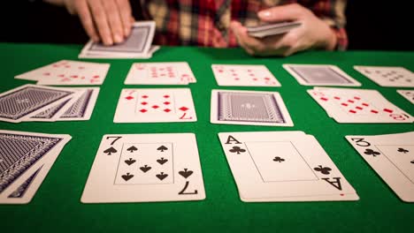 close up of female hands holding cards and playing solitaire