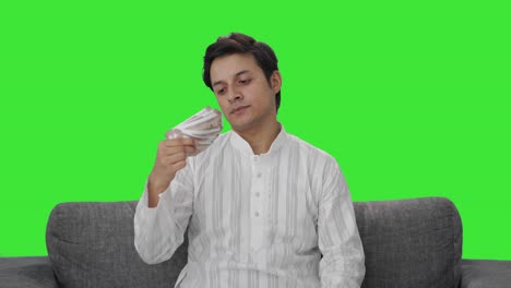 Rich-Indian-man-using-money-as-fan-Green-screen