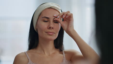 chica arreglada disfrutando de un masaje facial en el baño de cerca. concepto de cuidado anti-envejecimiento