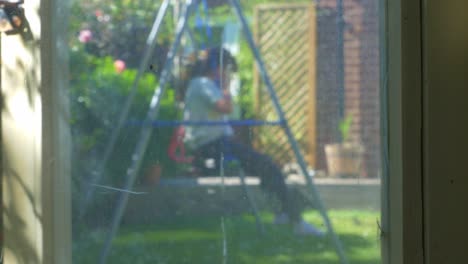unrecognisible girl, child, plays on english garden swing before running off