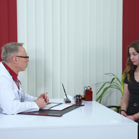 consultation in clinic. nice girl came to phisician for advi?e. senior professional medic discusses health issues with patient