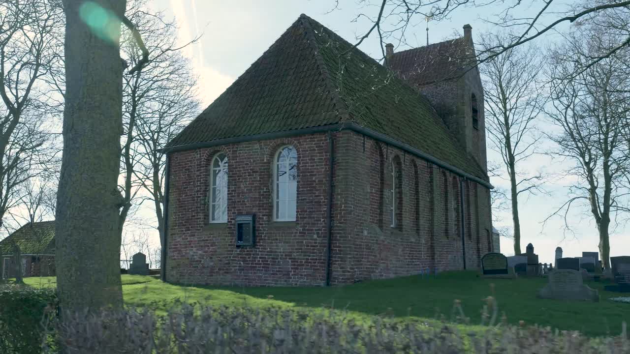 Chiesa storica in mattoni e cimitero in una giornata di sole