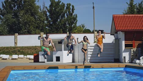 Enjoying pool party with friends. Group of beautiful young people looking happy while jumping into the swimming pool together