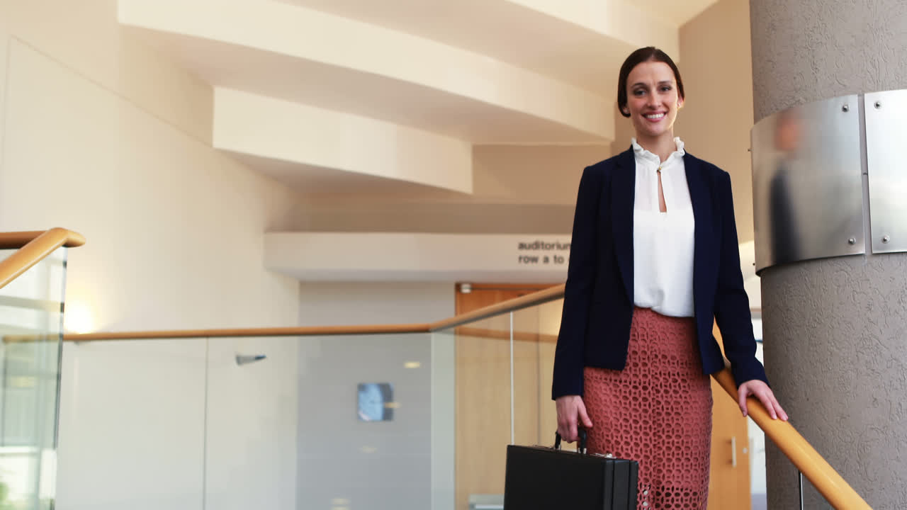 mujer de negocios de pie con maletín en las escaleras 4k