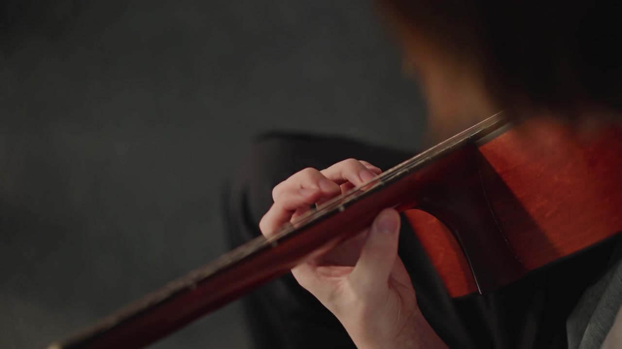 Closeup caucasian teacher fingering guitar, intimate school lesson in studio, coach guiding student through classical chord shapes, focused fingers on nylon strings, warm wooden body and fretboard