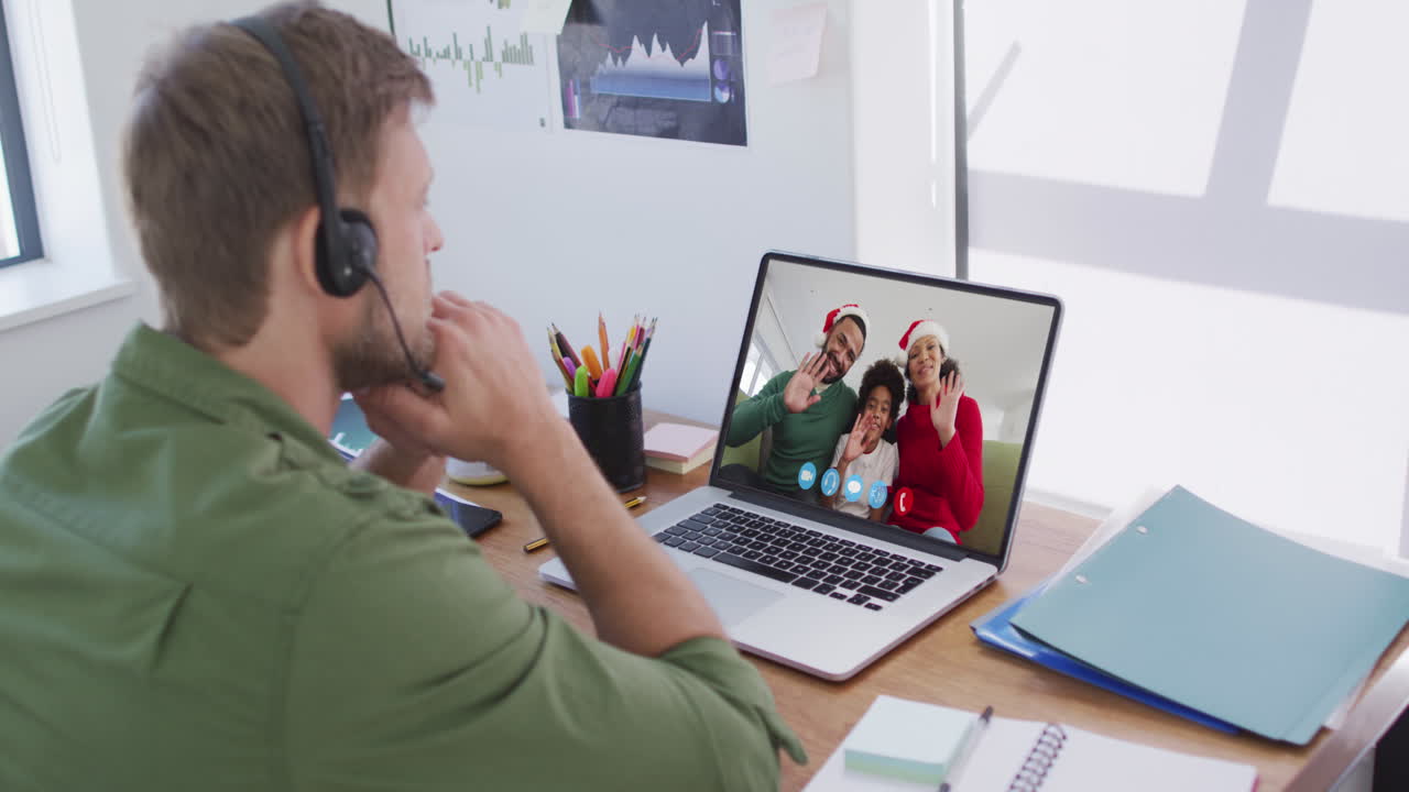 Kaukasisk mand bruger bærbar computer på videochat med familien i julen derhjemme.