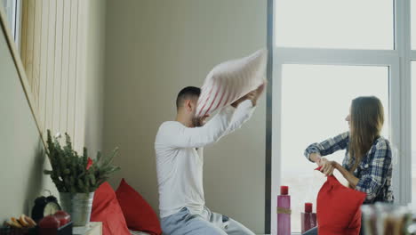 couple having a pillow fight in their cozy bedroom