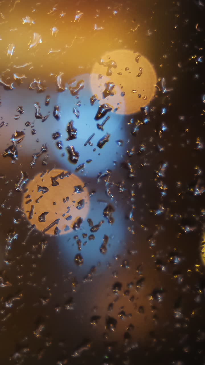 luces de la ciudad de la noche lluviosa a través de una ventana